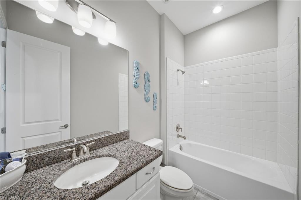 9658 Montelanico Loop, Unit 201 Naples, FL 34119 - Photo 20 of 46 a bathroom with a granite countertop sink toilet tub and shower