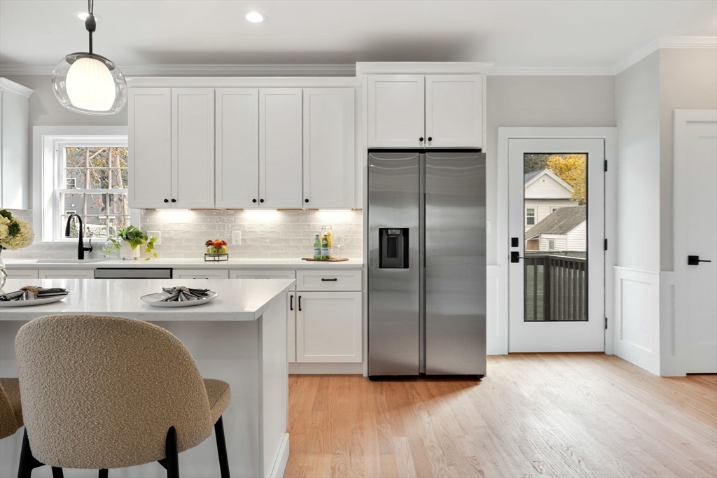 3-5 Victoria Road, Unit 3 Arlington, MA 02474 - Photo 11 of 36 a kitchen with stainless steel appliances granite countertop a refrigerator a sink a stove and white cabinets