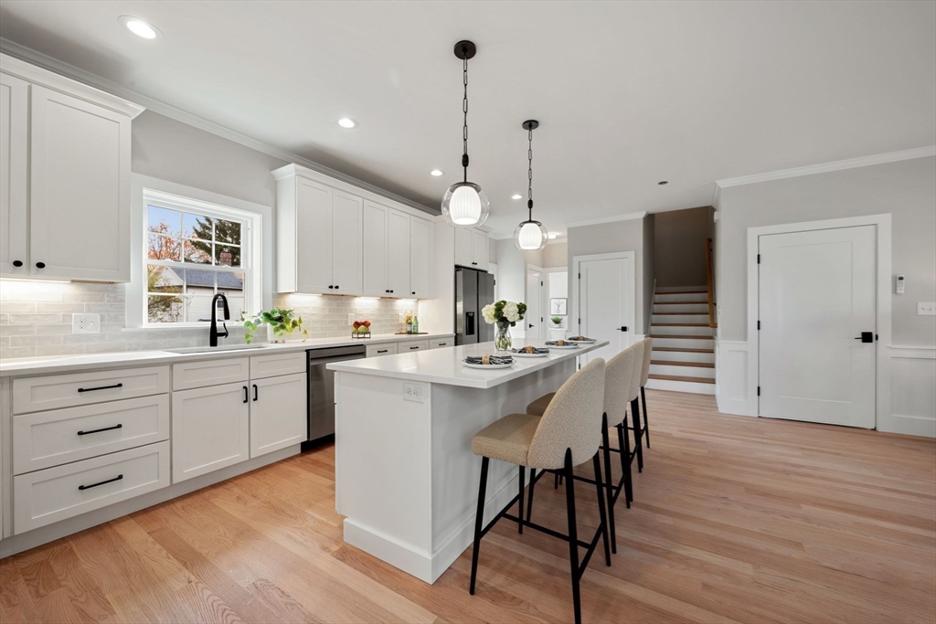 3-5 Victoria Road, Unit 3 Arlington, MA 02474 - Photo 9 of 36 a kitchen with white cabinets and stainless steel appliances