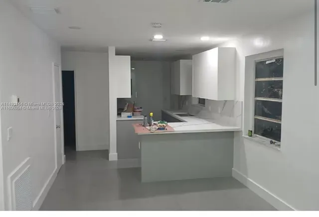 a kitchen with kitchen island a sink stainless steel appliances and cabinets