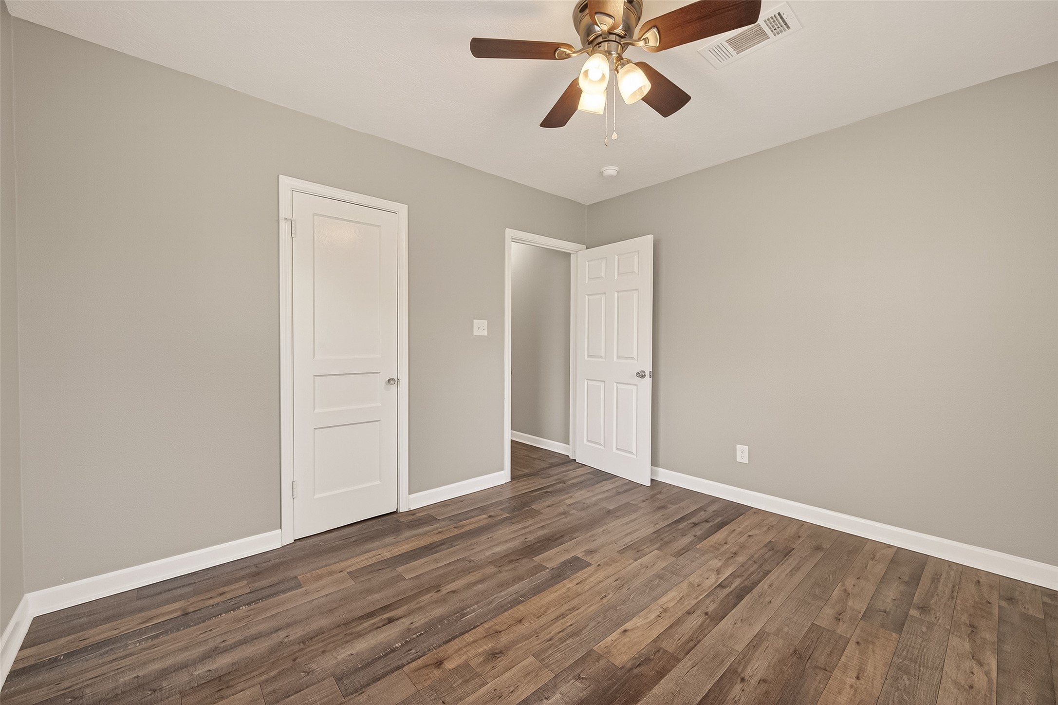 6615 Kernel Street Houston, TX 77087 - Photo 11 of 20 an empty room with wooden floor chandelier fan and closet area
