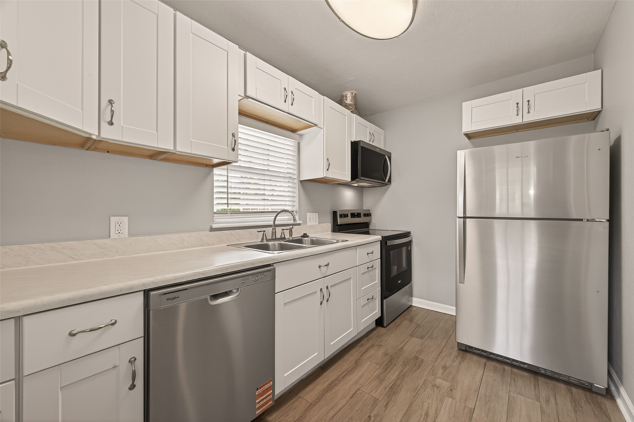 6615 Kernel Street Houston, TX 77087 - Photo 4 of 20 a kitchen with cabinets stainless steel appliances a sink and wooden floor