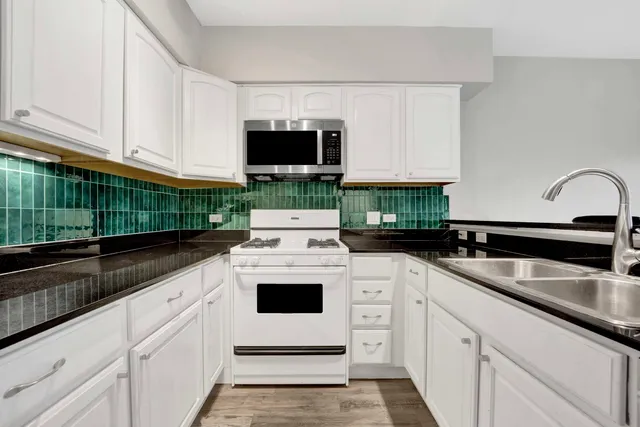 a kitchen with white cabinets and white appliances