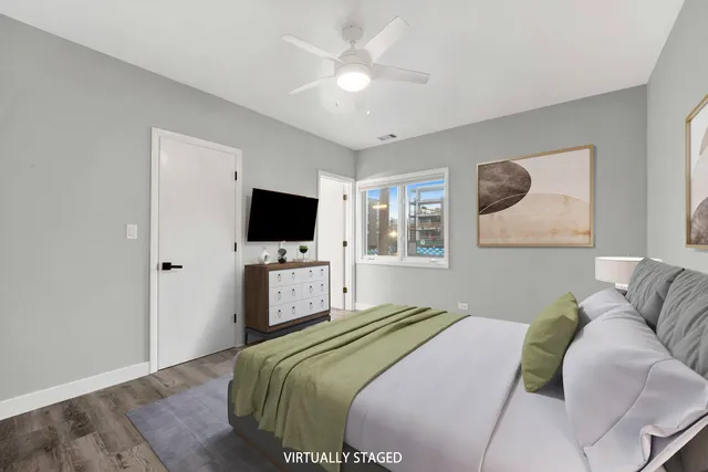 a bedroom with a large bed a flat screen tv and a chandelier