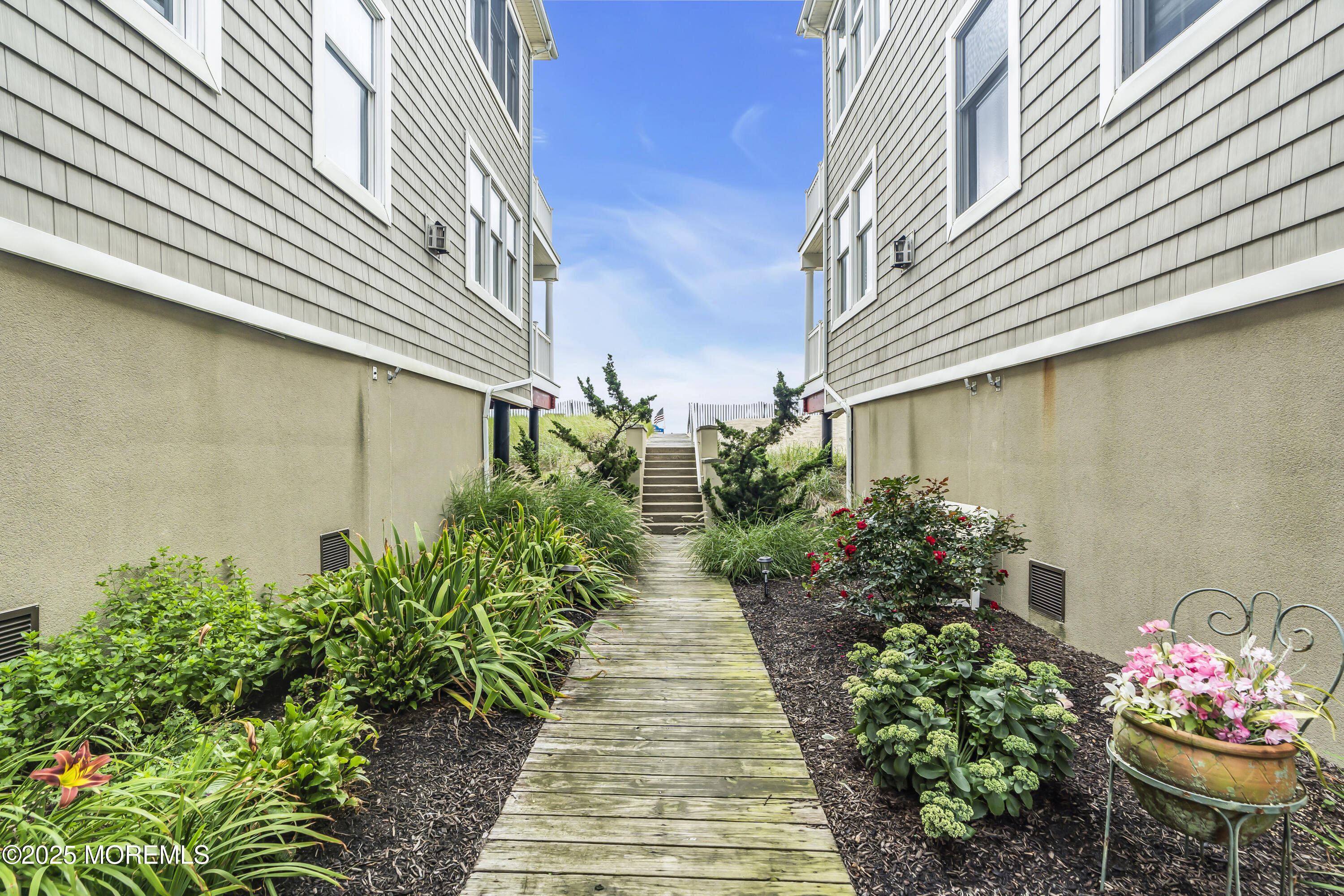 209 Beach Front, Unit 1 Manasquan, NJ 08736 - Photo 27 of 40 a view of a pathway with house on both side