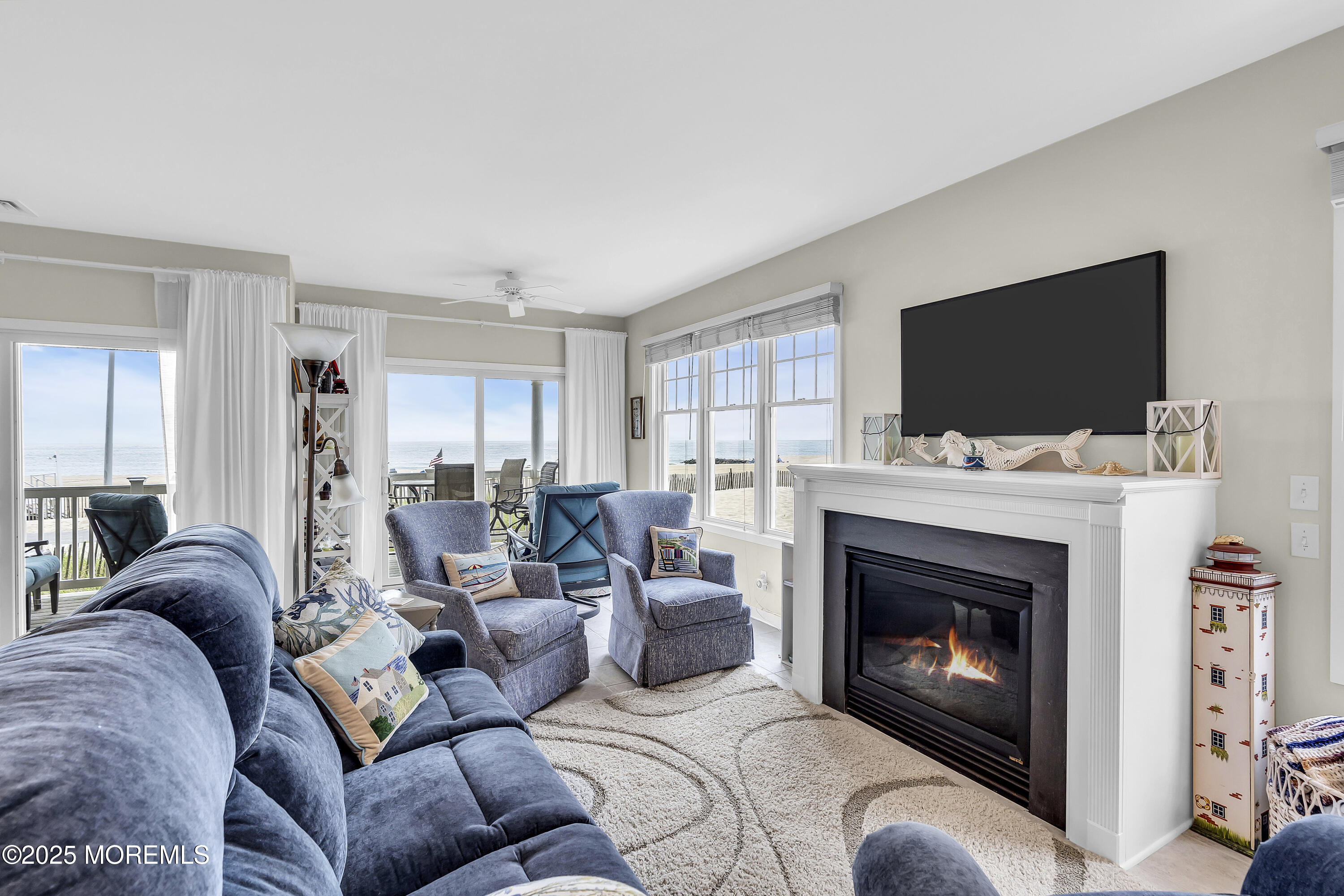 209 Beach Front, Unit 1 Manasquan, NJ 08736 - Photo 4 of 40 a living room with furniture a flat screen tv and a fireplace