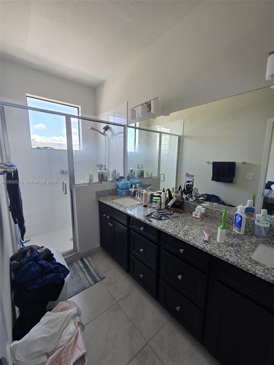 10847 Southwest 232nd Terrace Homestead, FL 33032 - Photo 23 of 29 a bathroom with a tub sink double vanity and a mirror