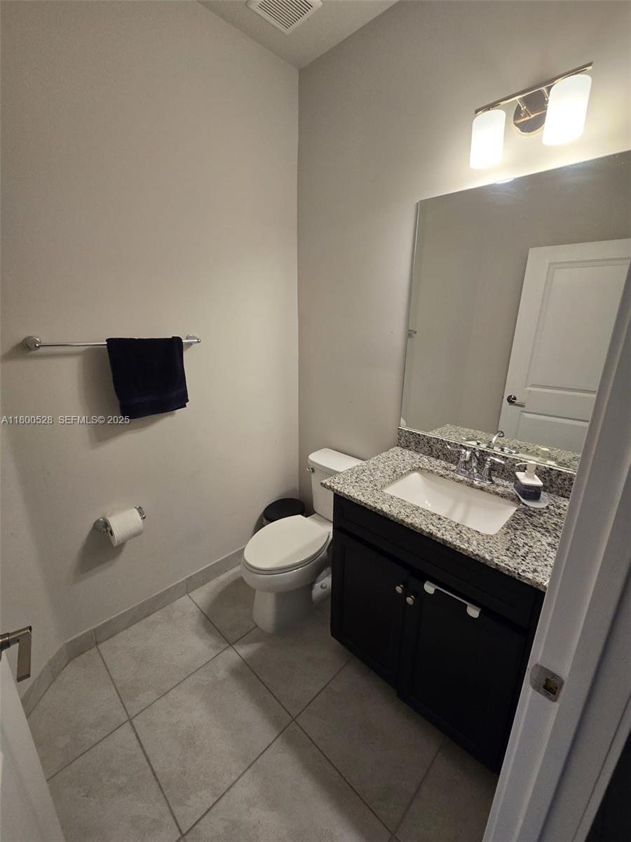 10847 Southwest 232nd Terrace Homestead, FL 33032 - Photo 7 of 29 a bathroom with a granite countertop toilet sink and mirror