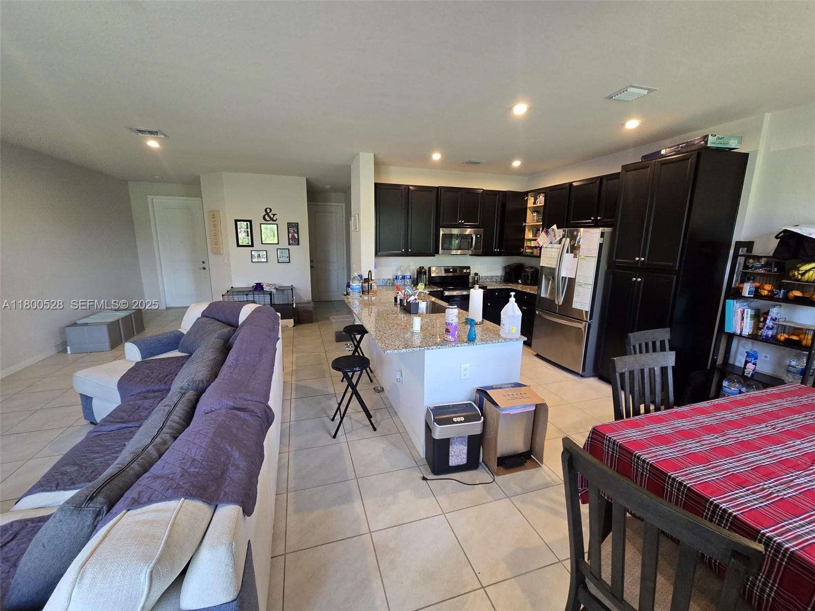 10847 Southwest 232nd Terrace Homestead, FL 33032 - Photo 9 of 29 a living room with furniture a flat screen tv and a table
