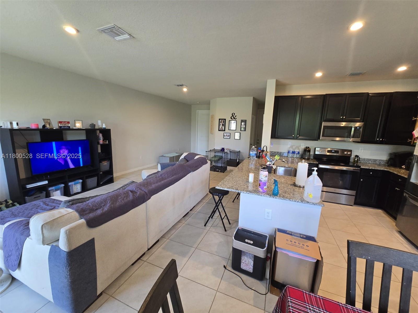 10847 Southwest 232nd Terrace Homestead, FL 33032 - Photo 10 of 29 a living room with furniture and a flat screen tv