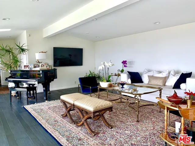 a living room with furniture a flat screen tv and a table