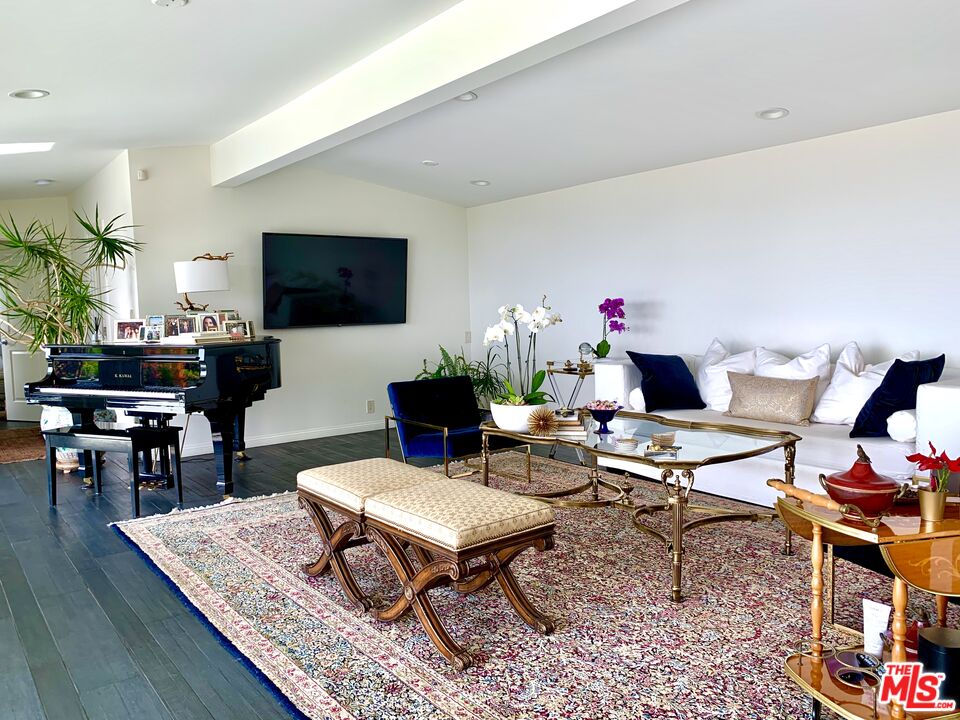 12250 Canna Road Los Angeles, CA 90049 - Photo 2 of 7 a living room with furniture a flat screen tv and a table