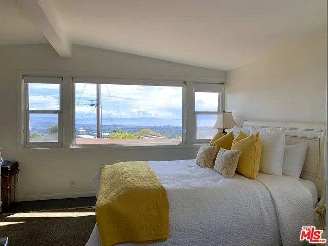 a bed sitting in a bedroom next to a window