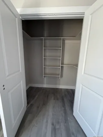 a view of walk in closet with empty racks