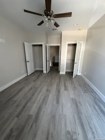 an empty room with wooden floor and closet