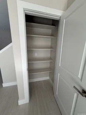 a view of walk in closet with empty racks