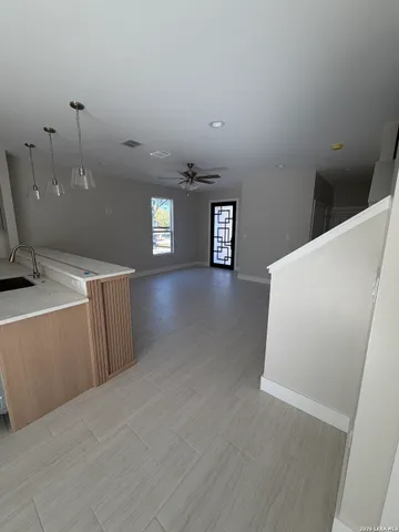 a view of an empty room with wooden floor and windows
