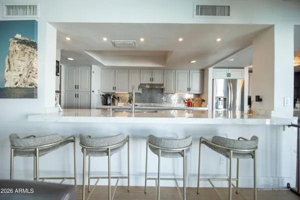 a kitchen with cabinets and chairs