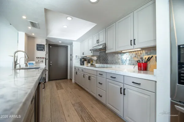 a kitchen with granite countertop a sink stainless steel appliances and cabinets