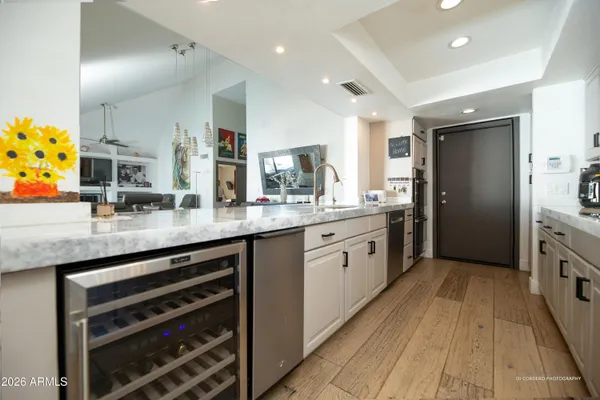 a large kitchen with stainless steel appliances granite countertop a lot of counter space and wooden floors