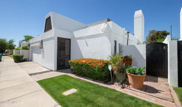a view of a potted plants next to a white house