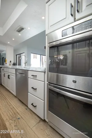 a kitchen with granite countertop white cabinets and white appliances