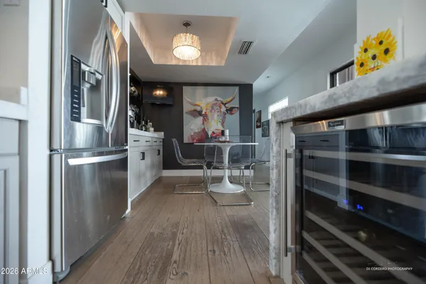 a kitchen with stainless steel appliances granite countertop a refrigerator and a wooden floors