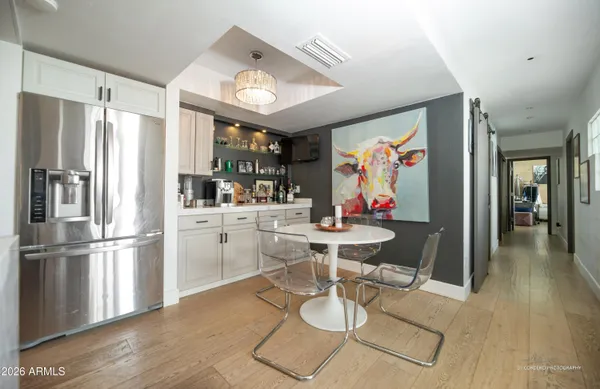 a kitchen with stainless steel appliances kitchen island granite countertop a refrigerator dining table and chairs