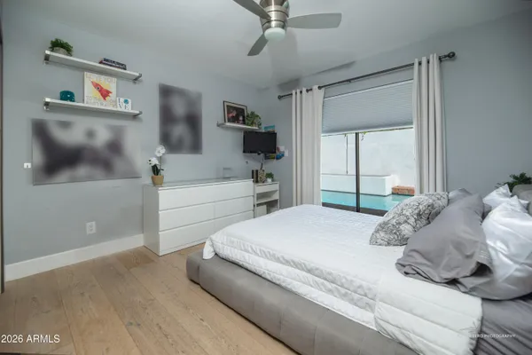 a bedroom with a bed and a flat tv screen on the dresser