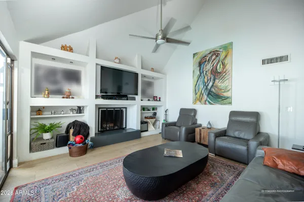 a living room with furniture a flat screen tv and a fireplace