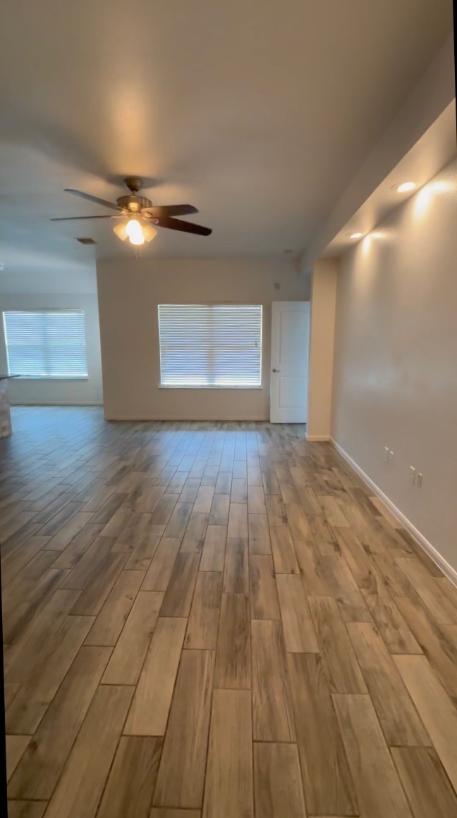 137 Rafe Court Kyle, TX 78640 - Photo 4 of 8 Plank-style tile flooring extends throughout this naturally illuminated living space, featuring a ceiling fan and recessed lighting.