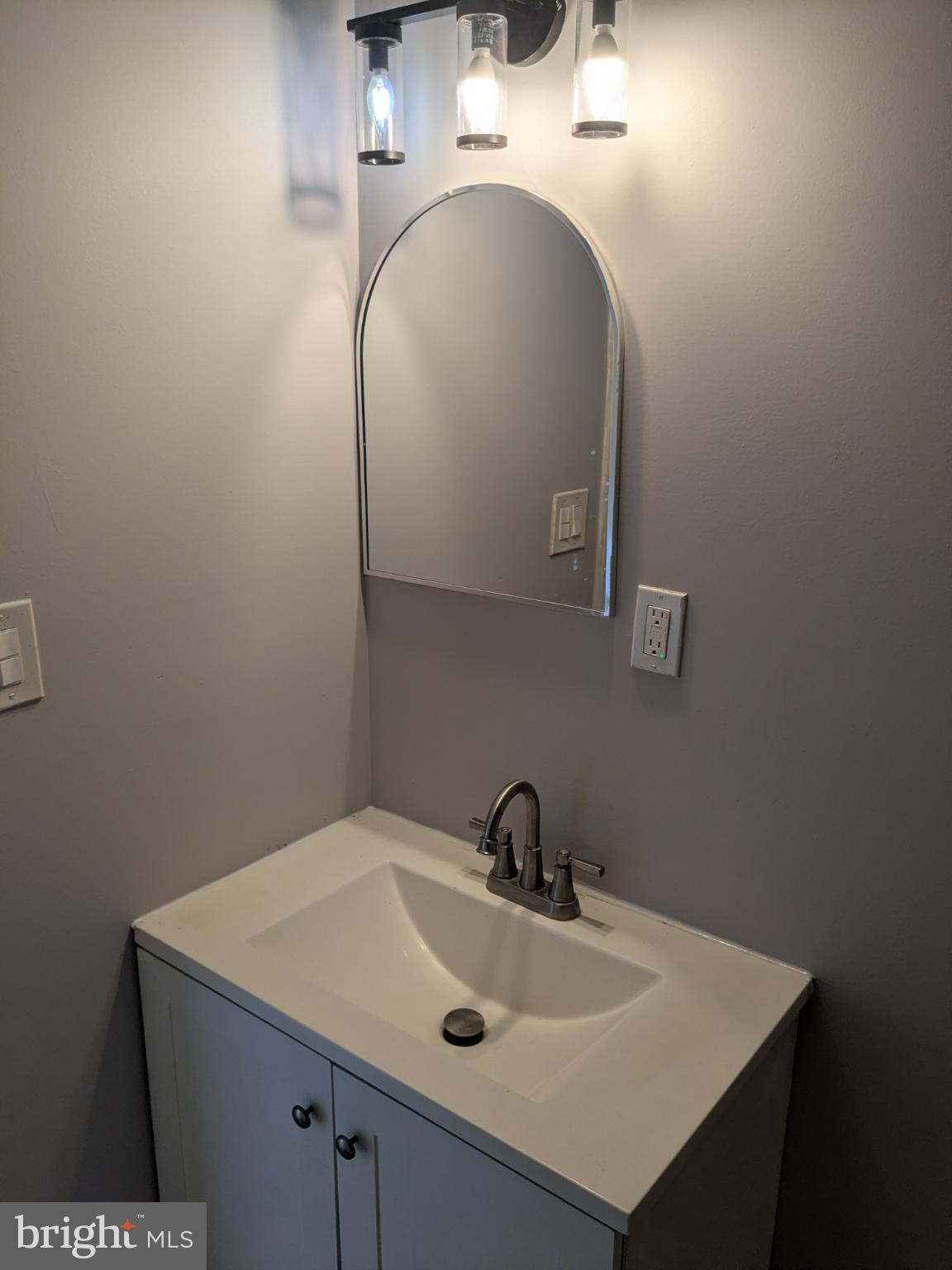 178 178-apt Hanover Street, Unit 2W Trenton, NJ 08618 - Photo 14 of 22 a bathroom with a sink and mirror