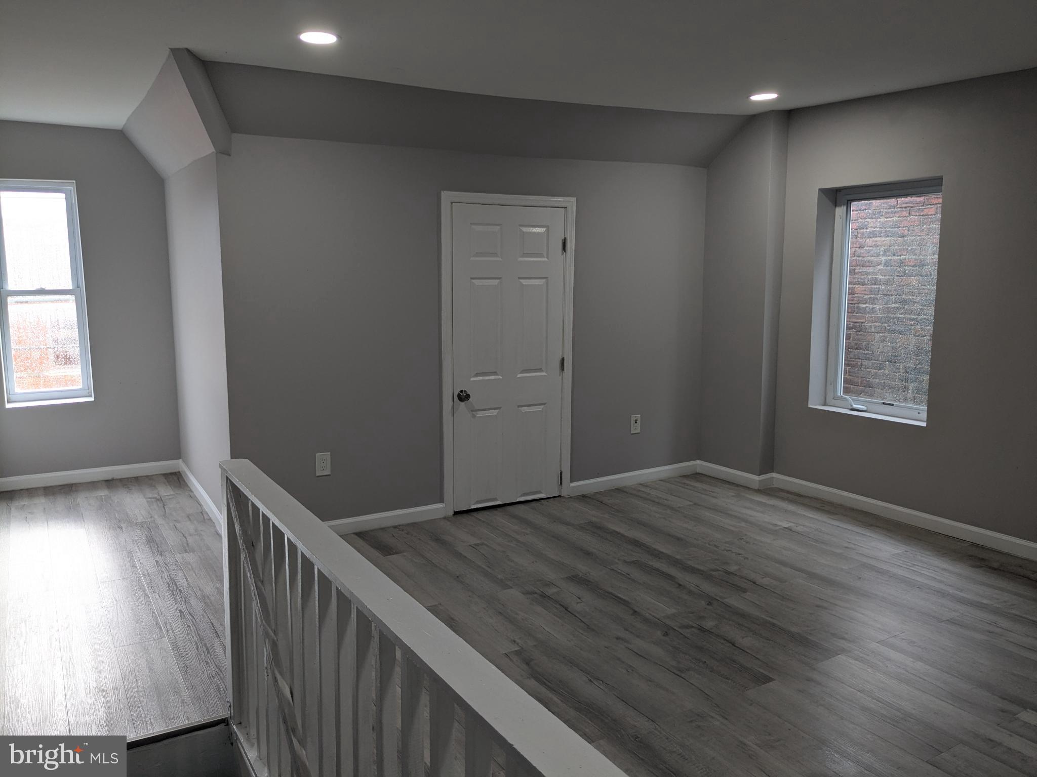 178 178-apt Hanover Street, Unit 2W Trenton, NJ 08618 - Photo 18 of 22 an empty room with wooden floor and windows