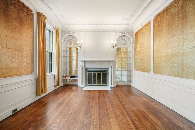 a view of a livingroom with wooden floor and a fireplace