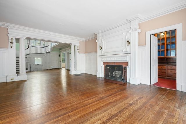 a view of a livingroom with wooden floor and a fireplace