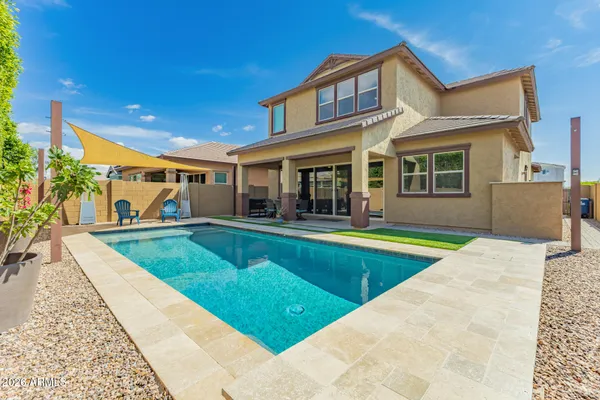 a view of a house with swimming pool and sitting area
