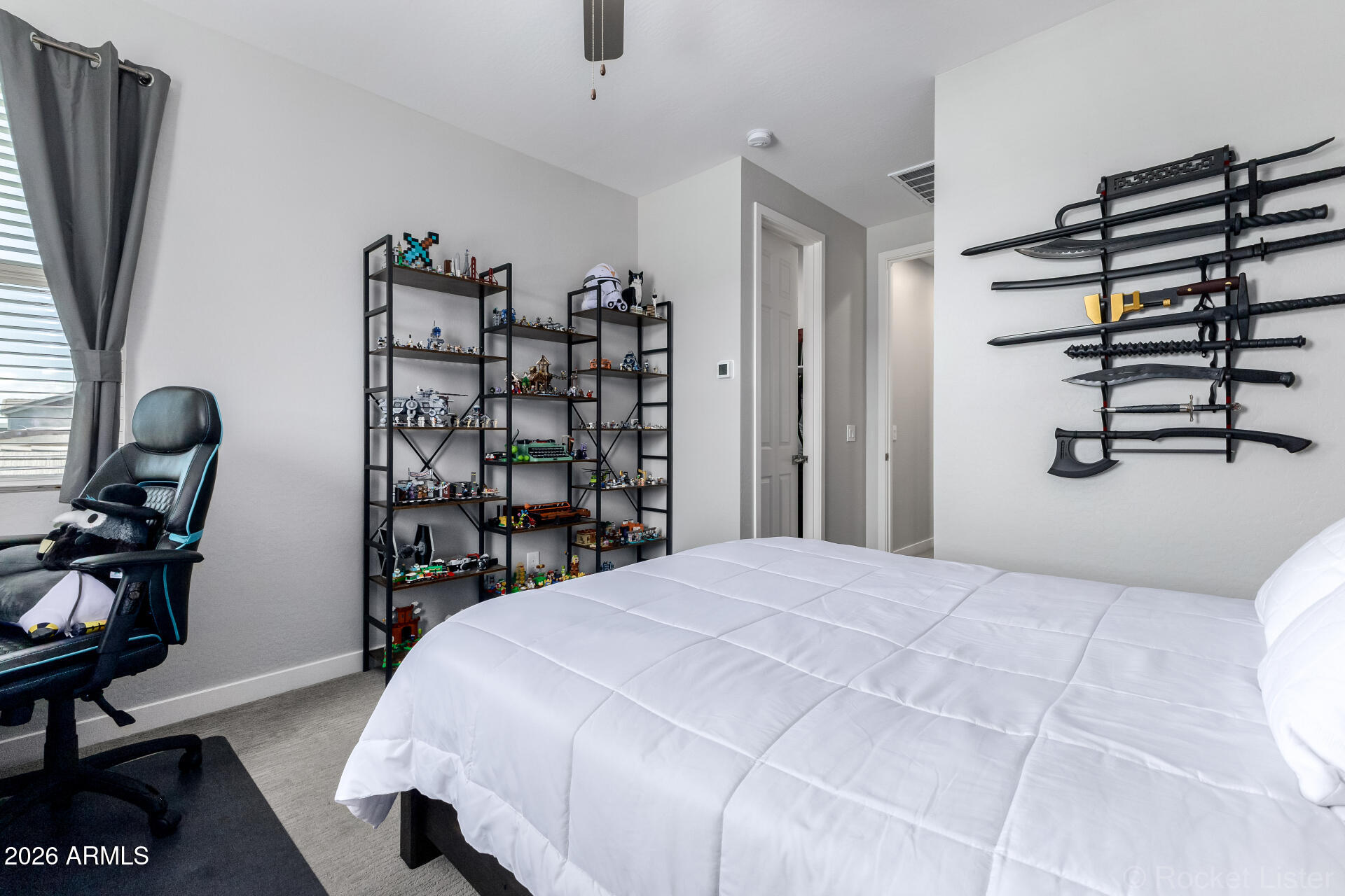 3494 East Spring Wheat Lane Gilbert, AZ 85296 - Photo 23 of 39 a bedroom with a bed a computer on the desk and a book shelf