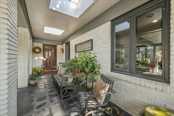a living room with furniture a flat screen tv and a large window