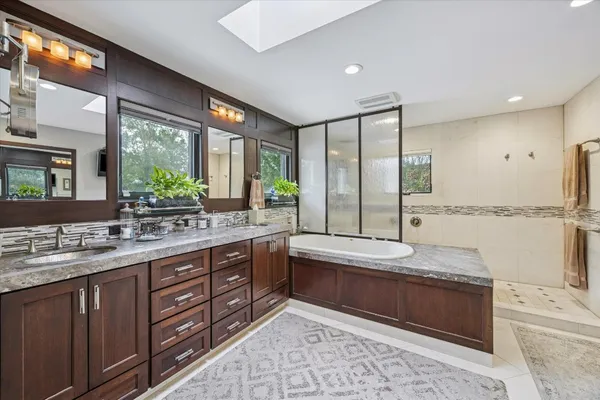 a bathroom with a granite countertop sink mirror and shower