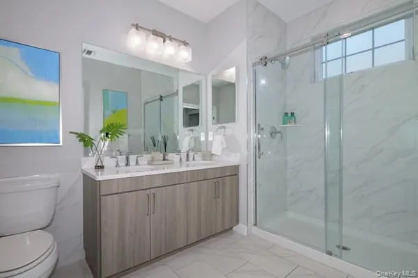 a bathroom with a sink toilet a mirror and shower