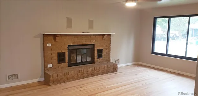 a living room with a fireplace and wooden floor