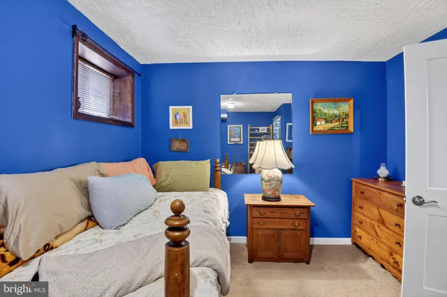 a bed sitting in a bedroom next to a window