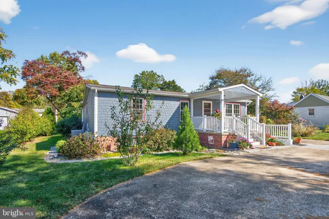 a front view of a house with a yard and potted plants