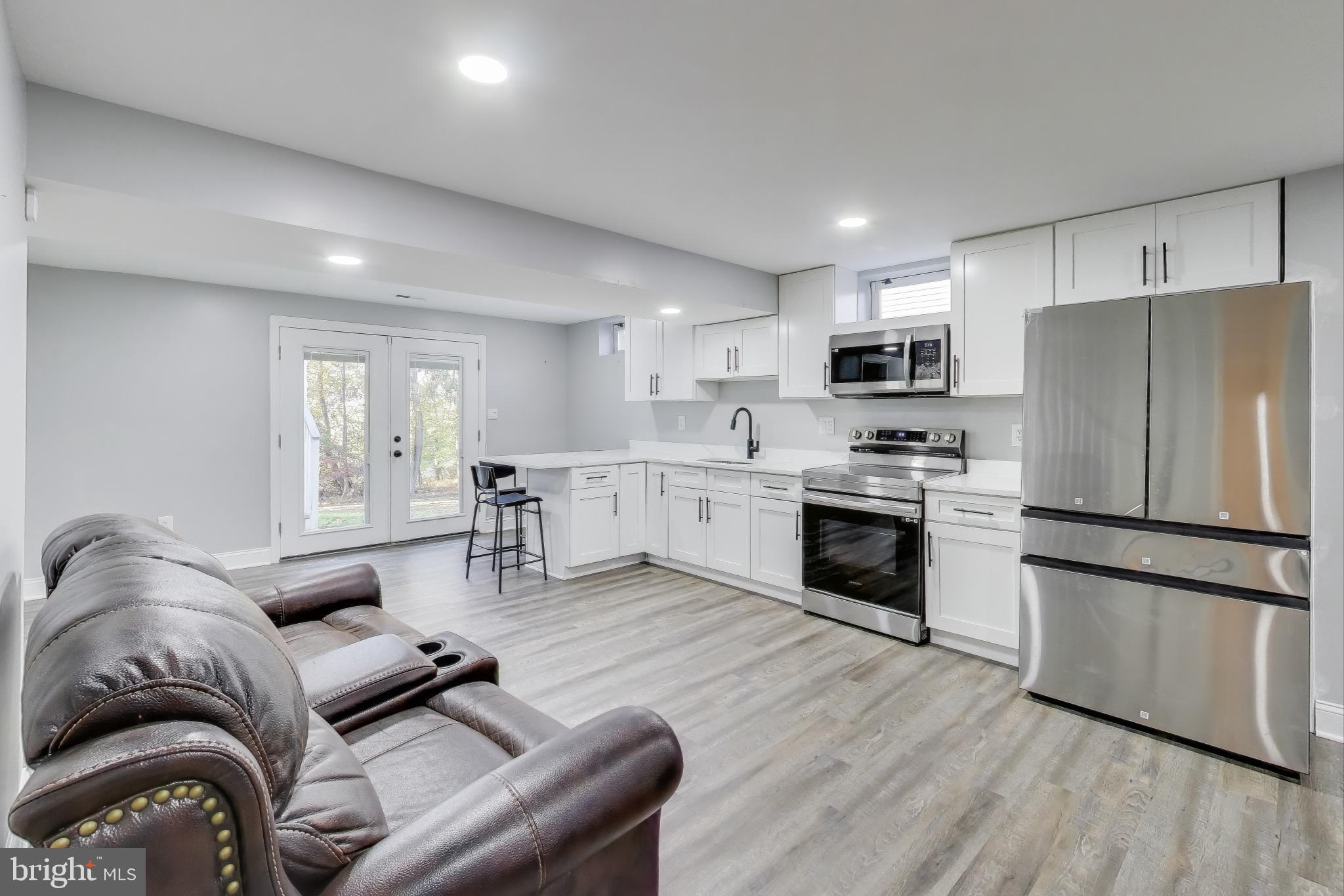 16702 Gooseneck Terrace Olney, MD 20832 - Photo 41 of 65 a kitchen with a refrigerator a stove top oven a sink dishwasher and white cabinets with wooden floor