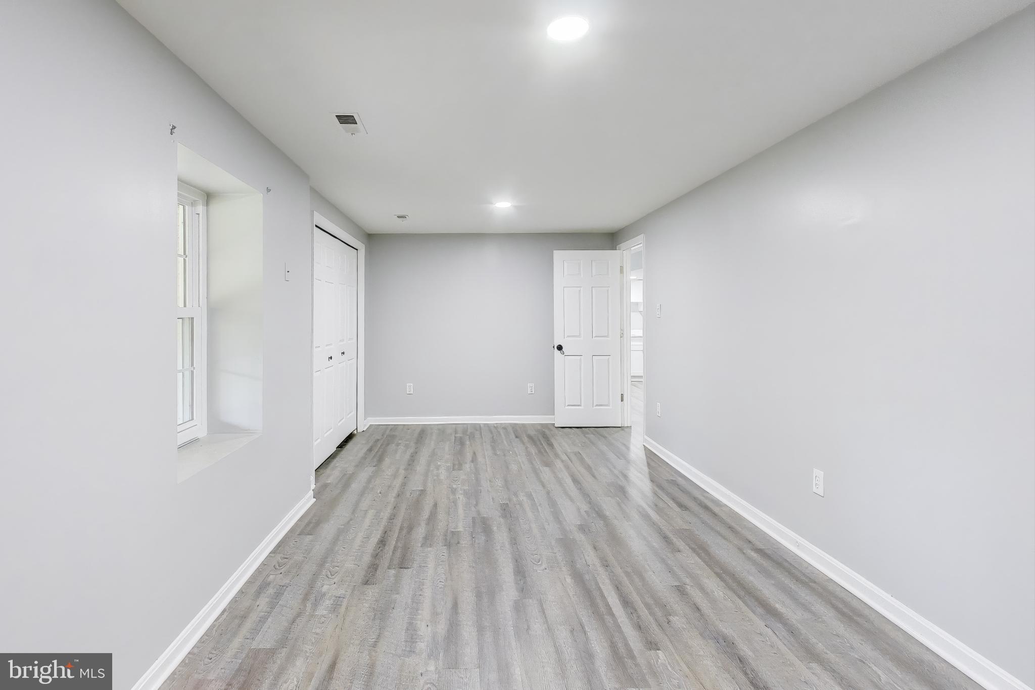 16702 Gooseneck Terrace Olney, MD 20832 - Photo 45 of 65 a view of an empty room with wooden floor and a window