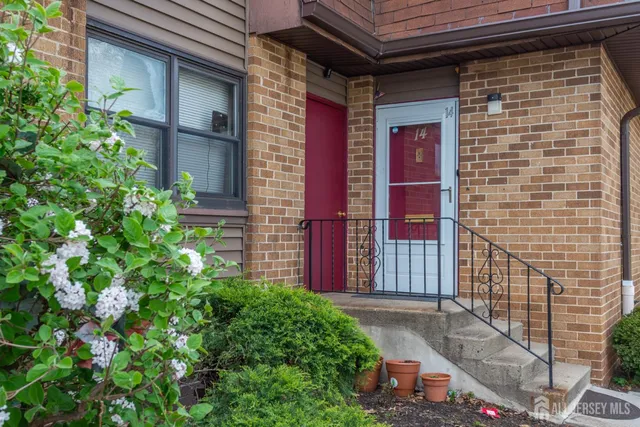 a view of a brick house with a flower garden