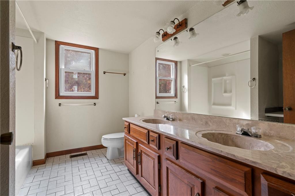 5414 Price Road Gainesville, GA 30506 - Photo 78 of 82 a bathroom with a granite countertop double vanity sink a mirror and a toilet