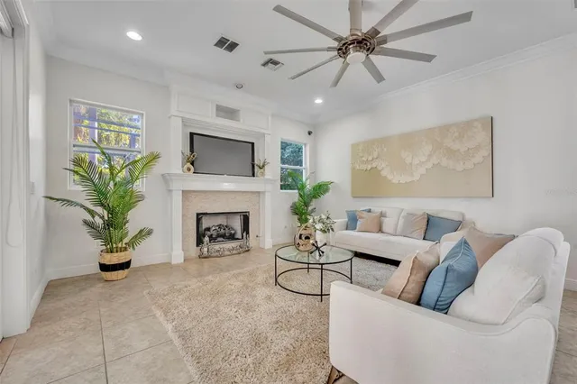 a living room with furniture a fireplace and a potted plant
