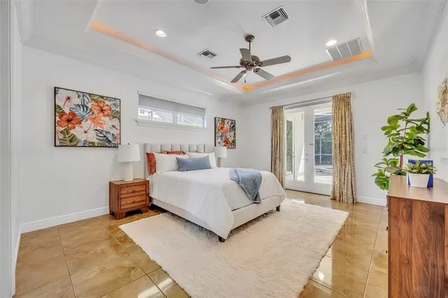 a spacious bedroom with a large bed and a chandelier
