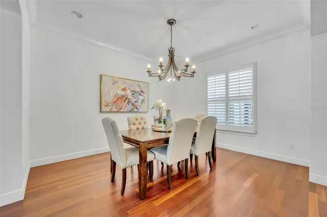 a dining room with furniture a chandelier and wooden floor
